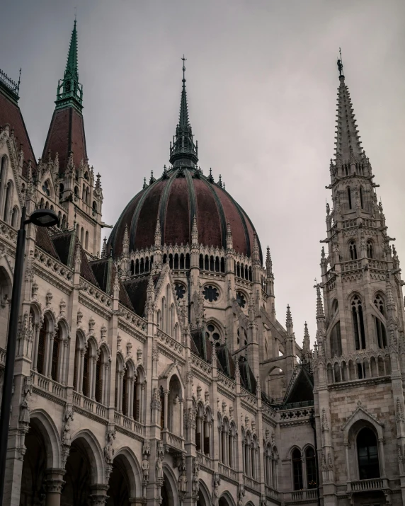 a large building with a clock on the front of it, inspired by Mihály Munkácsy, pexels contest winner, black domes and spires, thumbnail, leader of fascist hungary, background image