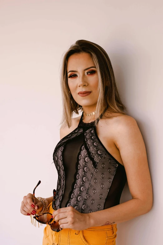 a beautiful young woman standing next to a white wall, by Robbie Trevino, wearing a black bodysuit, wearing silver dress, dressed in black lace, profile image