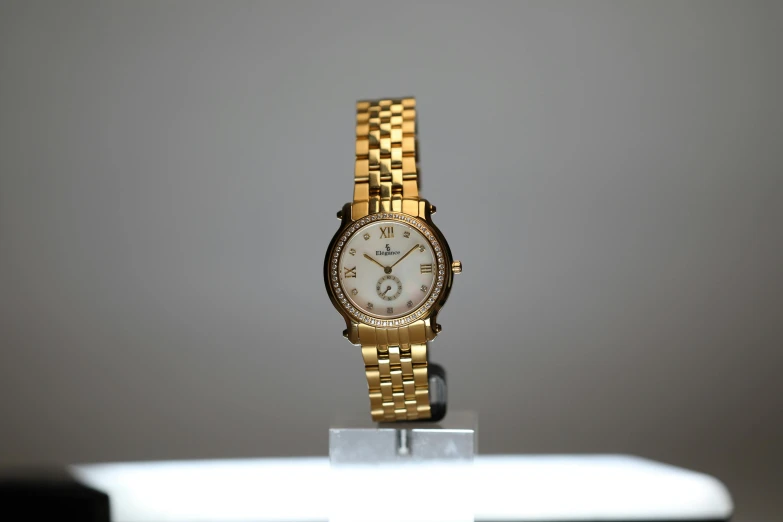 a close up of a watch on a table, by Gavin Hamilton, realistic gold, on display ”, fujifilm”, mid 2 0's female