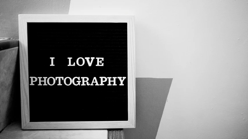 a black and white photo of a sign that says i love photography, a black and white photo, inspired by Dorothea Lange, unsplash, art photography, still life photo studio, !!! colored photography, ariana grande photography, style of pinhole photography