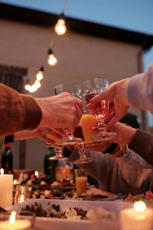 a group of people toasting at a dinner table, pexels contest winner, renaissance, holiday, holding a drink, low quality photo, cozy