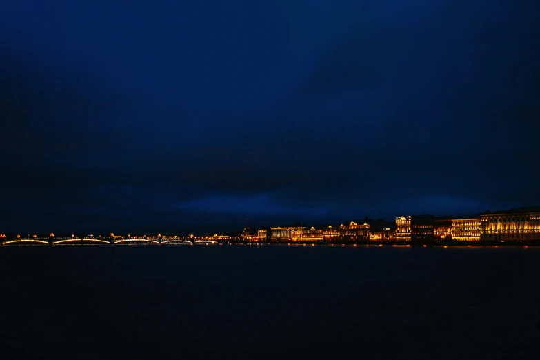 a bridge over a body of water at night, a picture, by Adam Szentpétery, city panorama, overcast bokeh - c 5, midnight blue, budapest