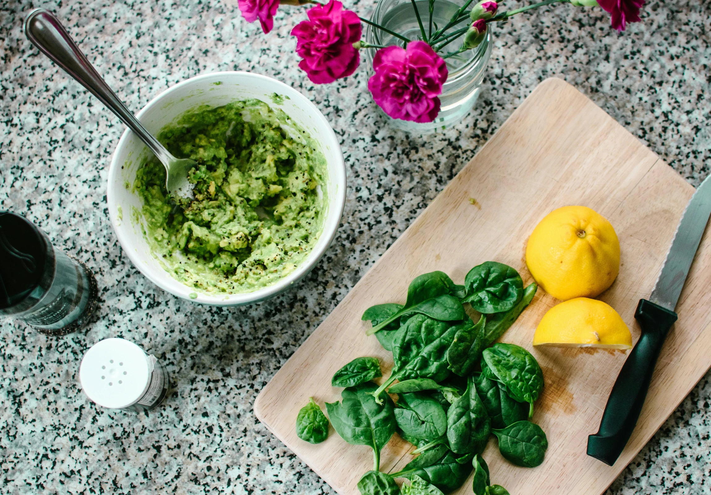 a wooden cutting board topped with spinach and lemons, trending on unsplash, process art, green eggs and ham, green facemask, green and purple, kitchen counter