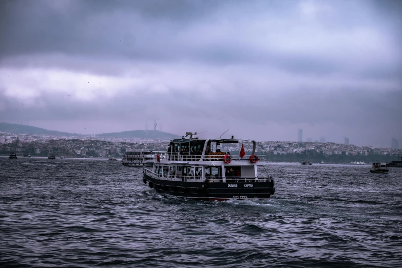 a large boat floating on top of a body of water, by Ismail Acar, pexels contest winner, hurufiyya, istanbul, overcast gray skies, thumbnail, black