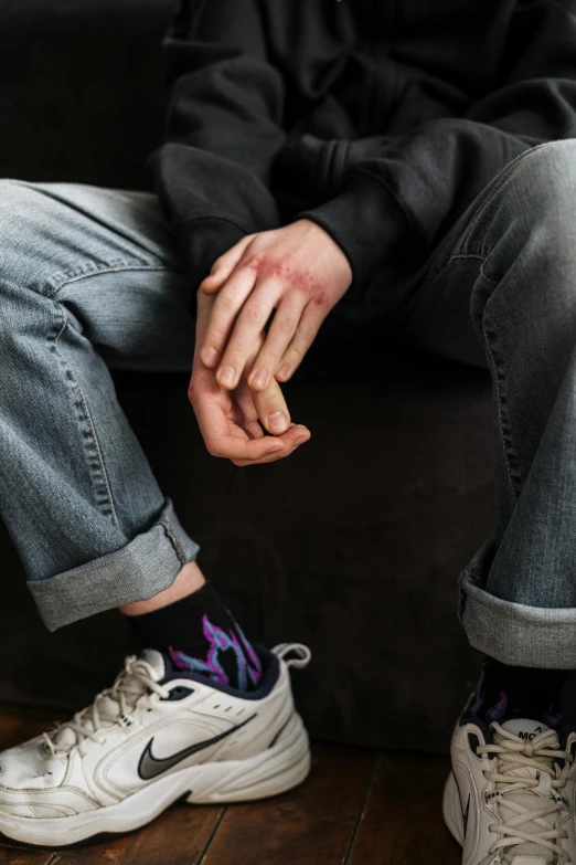 a close up of a person sitting on a couch, trending on pexels, wearing ragged clothing, 5 fingers). full body, scarred, teen boy