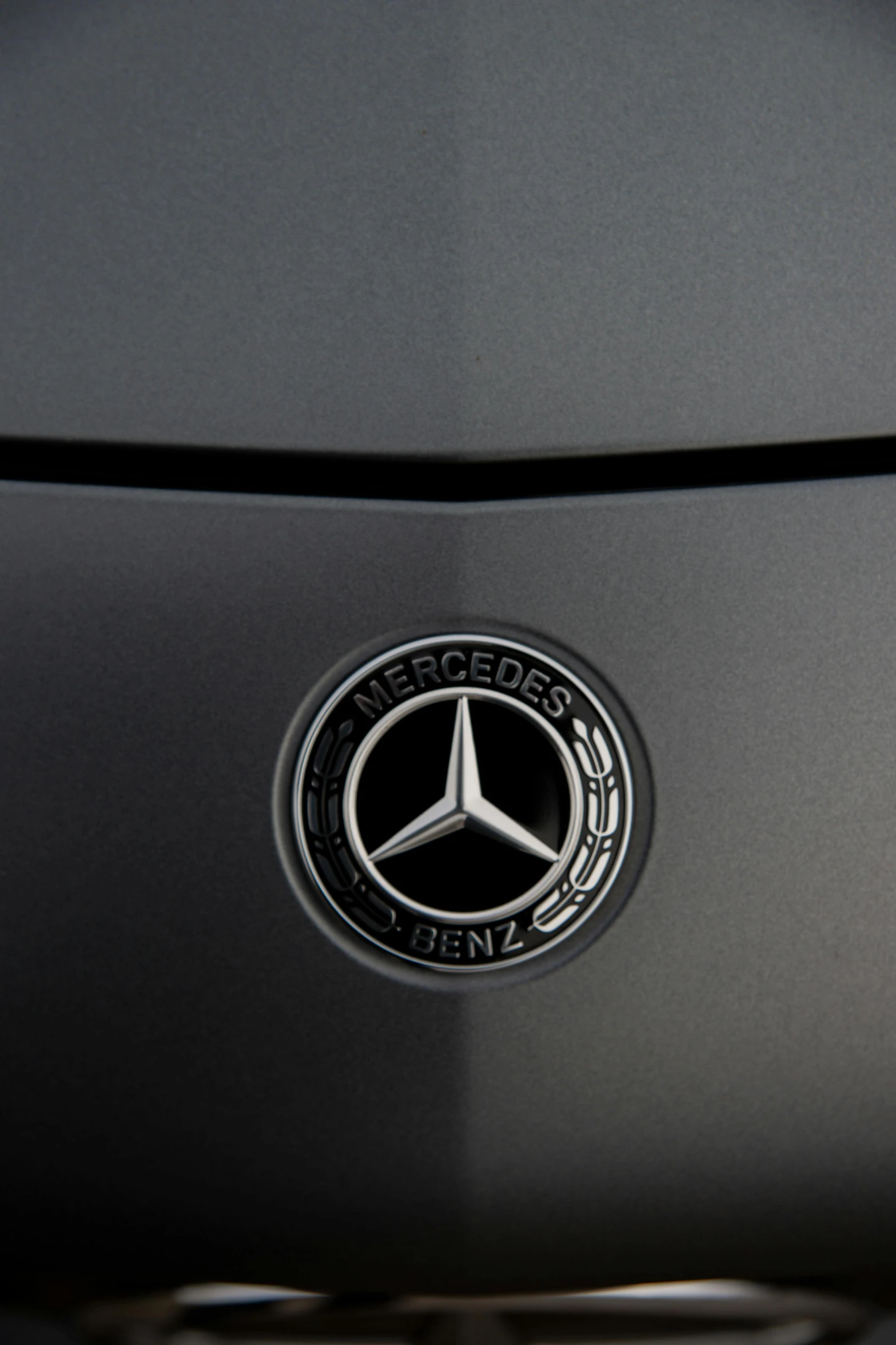 a mercedes emblem on the hood of a car, unsplash, matte paint, gun metal grey, taken with sony alpha 9, made of metal