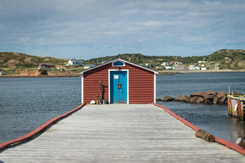a red building sitting on top of a pier next to a body of water, a portrait, fishing village, bonnie maclean, landscape photo