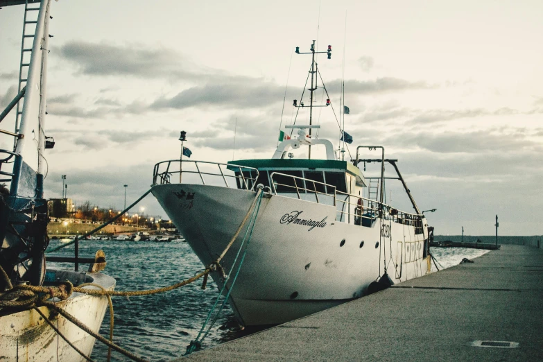 a large white boat sitting on top of a body of water, a portrait, unsplash, hurufiyya, fishing town, marina federovna, nostalgic 8k, manly