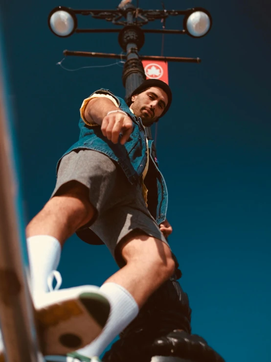 a man riding a skateboard up the side of a metal pole, by Lee Gatch, hyperrealism, looking up at camera, low quality photo, trending on r/streetwear, climber