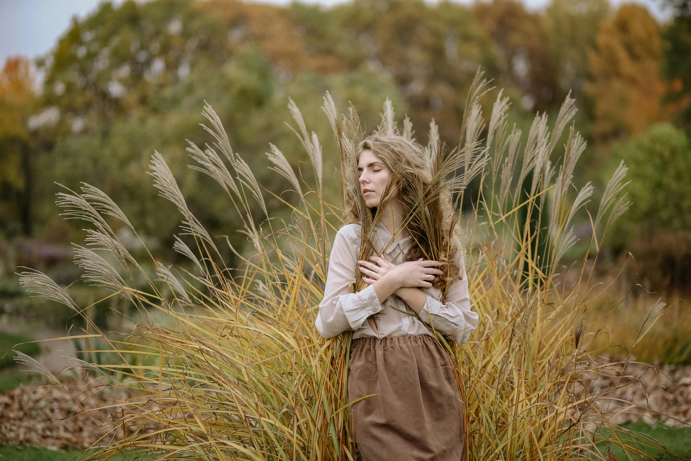 a woman standing in a field of tall grass, a portrait, inspired by Anka Zhuravleva, unsplash, renaissance, brown clothes, medium format, portrait image