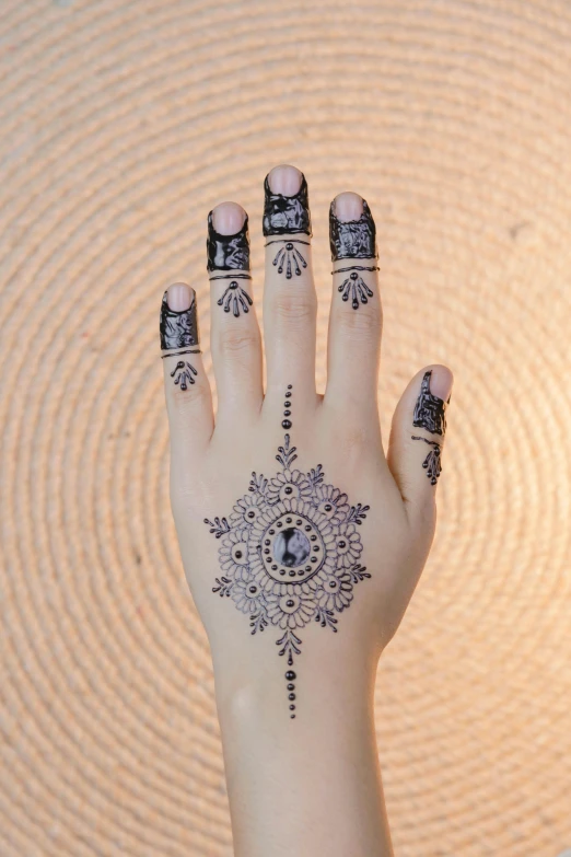 a close up of a person's hand with a tattoo on it, arabesque, glitter accents on figure, india ink, 5 fingers, lacey accessories