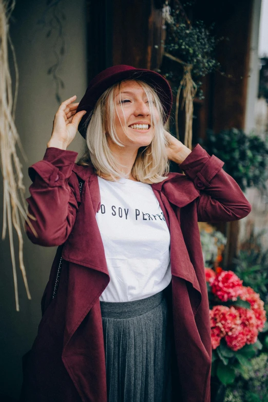 a woman wearing a t - shirt that says do say please, by Julia Pishtar, pexels contest winner, private press, maroon hat, wearing trenchcoat, blond, positive and fun vibes