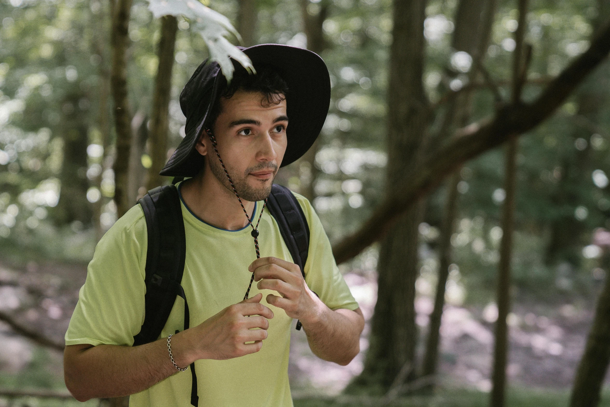 a man in a hat is walking through the woods, pexels contest winner, young greek man, green hat, avatar image, sports photo