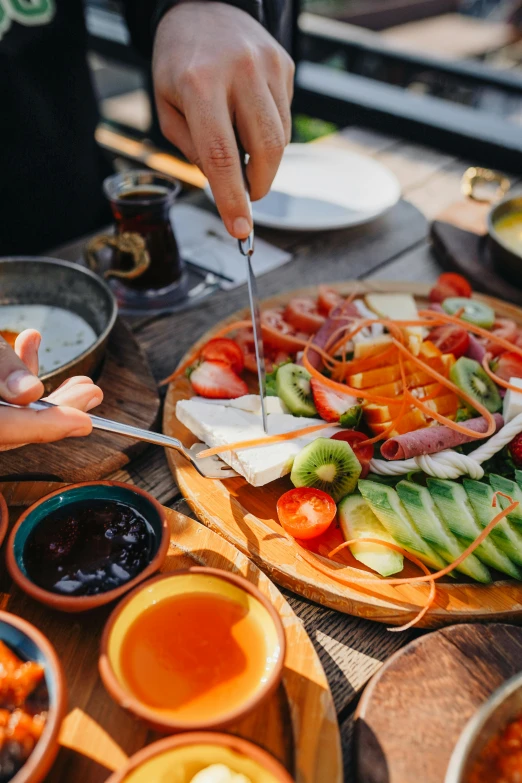 a wooden table topped with plates of food, pexels contest winner, eating a cheese platter, sun drenched, australian, salad