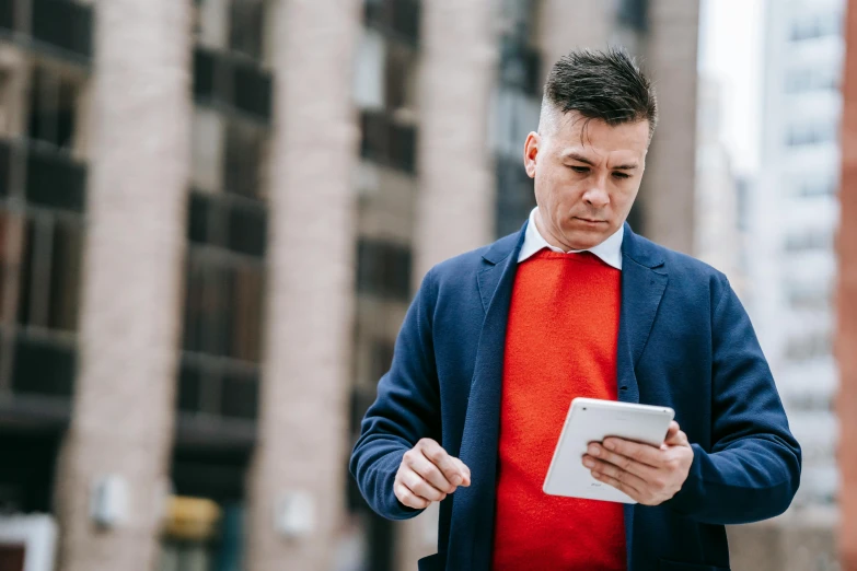 a man in a red shirt and blue jacket looking at a tablet, by Sebastian Vrancx, pexels, wearing business casual dress, man walking, instagram post, middle aged man