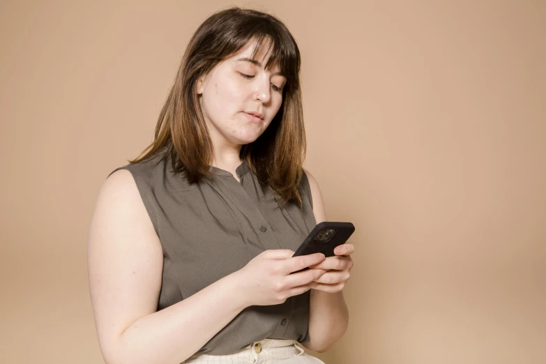 a woman is looking at her cell phone, trending on pexels, renaissance, brown shirt, plain background, charli bowater, avatar image