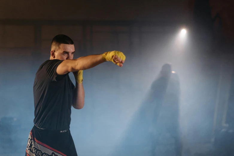 a man in black shirt throwing a yellow glove, inspired by Ma Quan, unsplash, realism, mma southpaw stance, background image, performance, behind the scenes photo