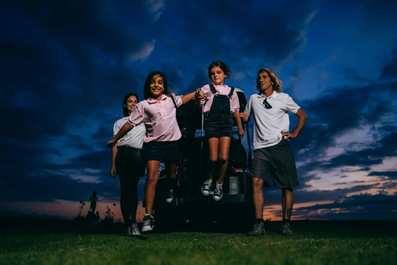 a group of young people standing on top of a truck, by Dan Luvisi, pexels contest winner, wearing school uniform, standing in the grass at sunset, on black background, wearing golf shorts