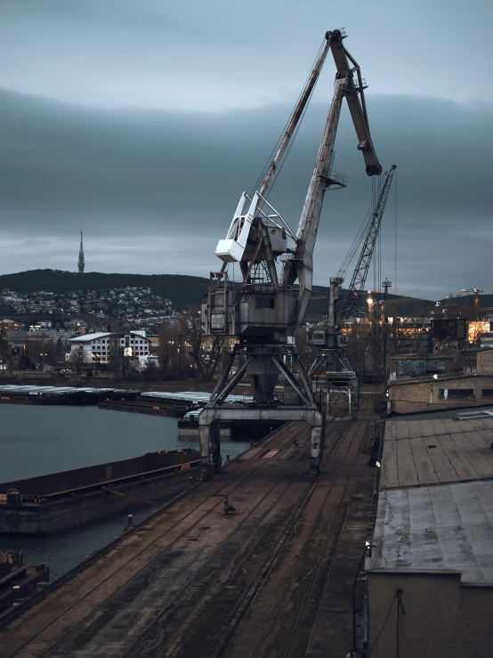 a crane sitting on top of a dock next to a body of water, inspired by Elsa Bleda, pexels contest winner, happening, soviet yard, dark grey, harbor, high quality product image”