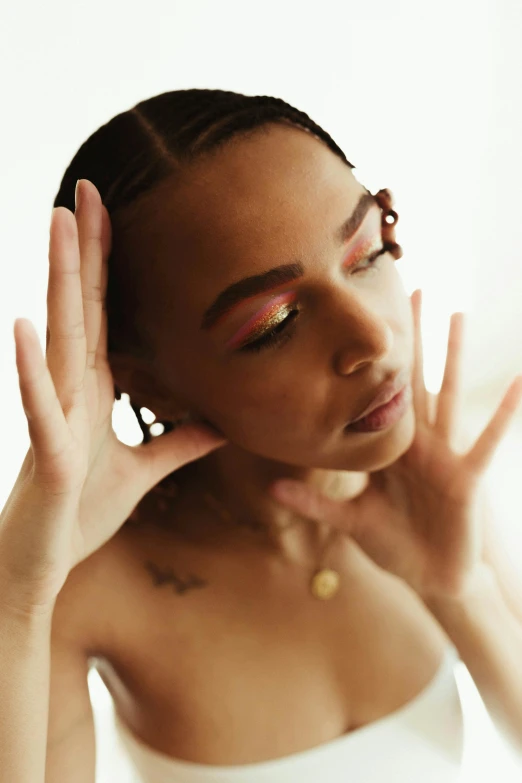 a woman in a white dress holding her hands up to her face, an album cover, by Dulah Marie Evans, trending on pexels, renaissance, cornrows braids, wet make - up, transparent vibrant glowing skin, non binary model