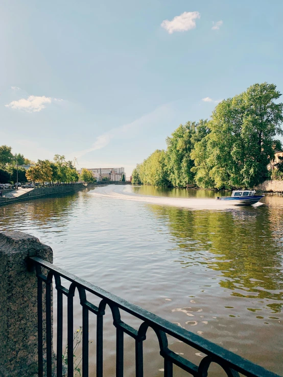 a boat traveling down a river next to a bridge, by Julia Pishtar, berlin park, peter the great, 🚿🗝📝, perfect crisp sunlight