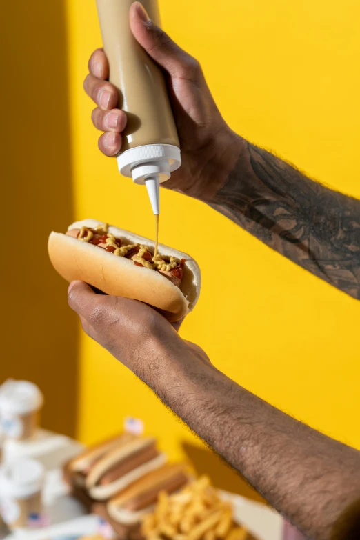 a close up of a person holding a hot dog, liquid gold, product shot, pouring, kano)