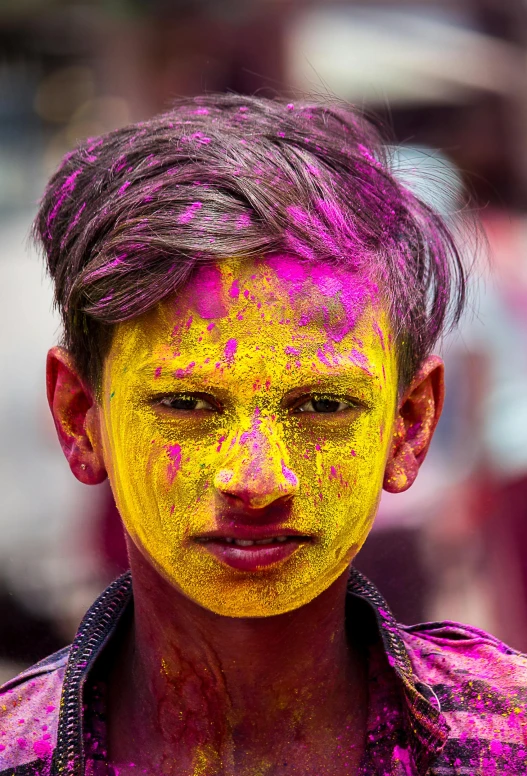 a man with pink and yellow paint on his face, a colorized photo, pexels contest winner, color field, 14 yo berber boy, nepal, colorful crowd, purple and yellow