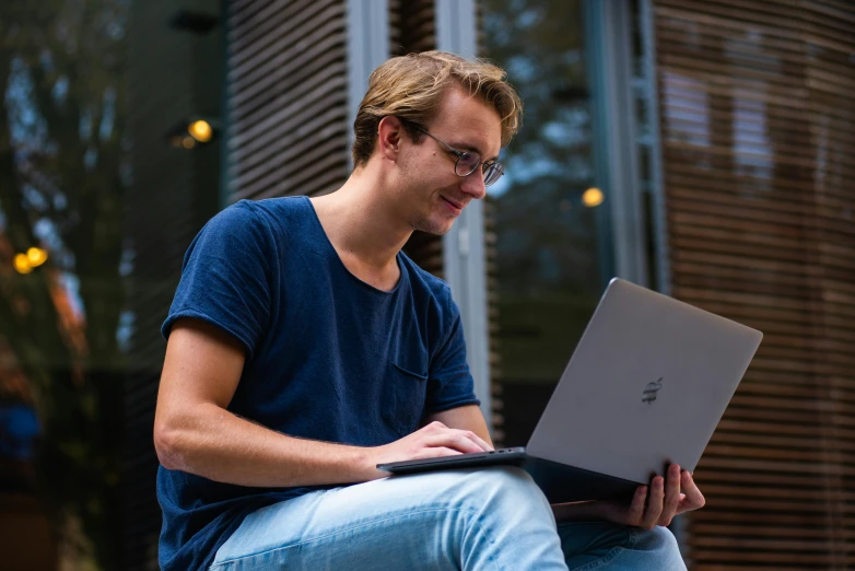 a man sitting on a bench using a laptop computer, a portrait, pexels contest winner, lachlan bailey, avatar image, student, high resolution image