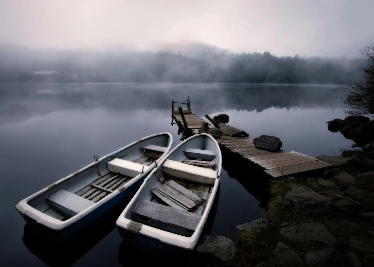 a couple of boats sitting on top of a lake, inspired by Pierre Pellegrini, pexels contest winner, romanticism, new hampshire, grey mist, lined up horizontally, cottagecore