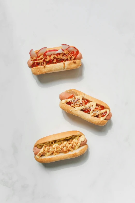 three hot dogs sitting next to each other on a table, product image, angled shot, araki, various styles