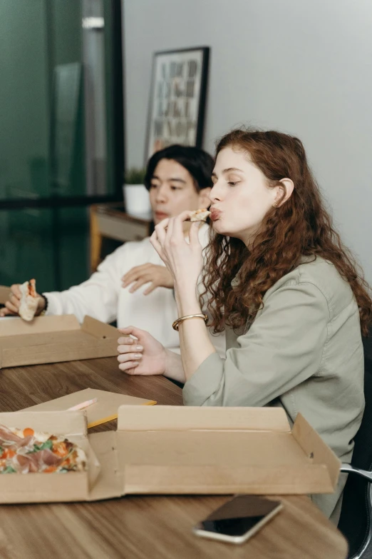 a group of people sitting around a table eating pizza, profile image, cardboard, asian female, extra crisp image