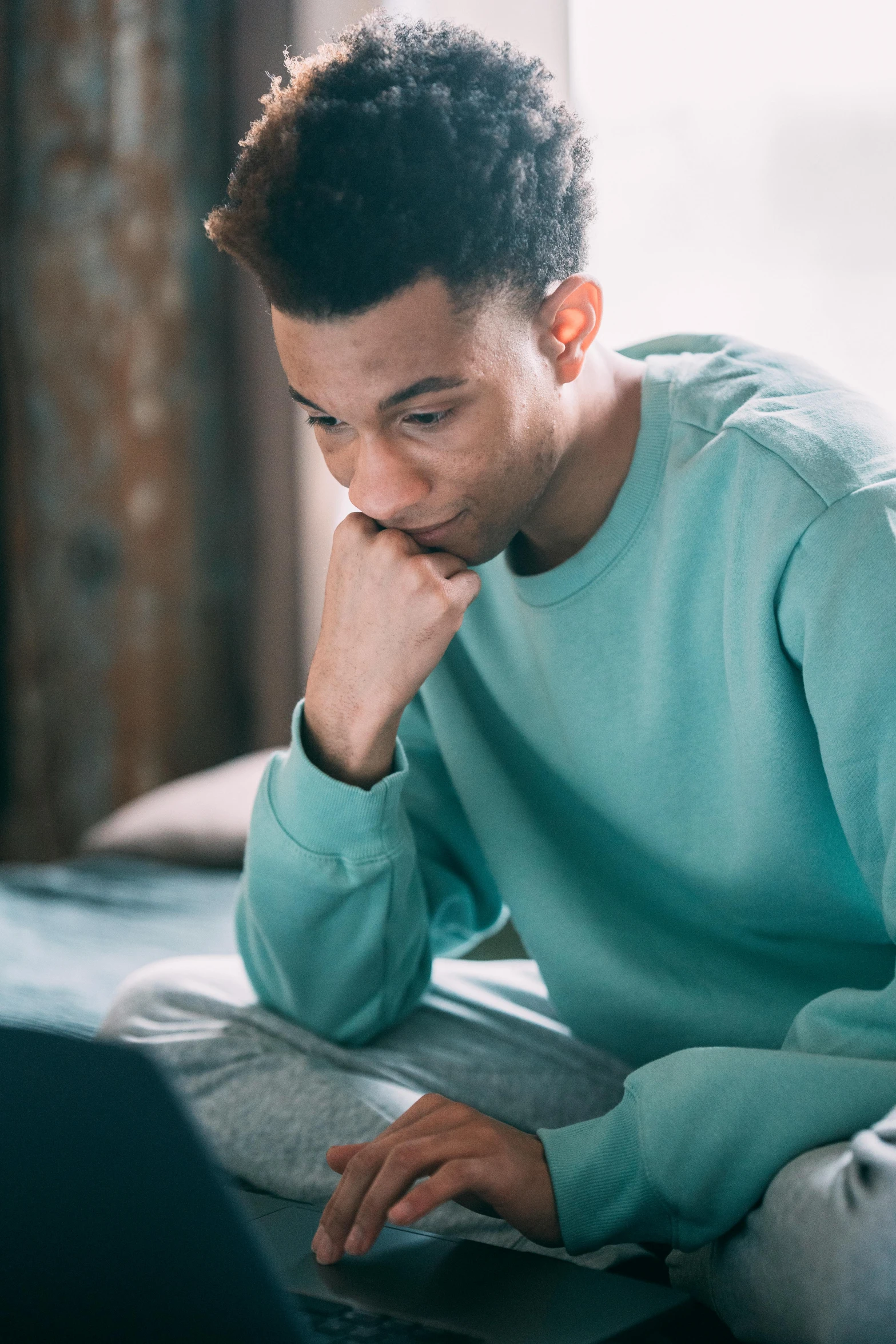 a man sitting on a bed using a laptop, trending on pexels, renaissance, with teal clothes, worried, jayson tatum, slide show