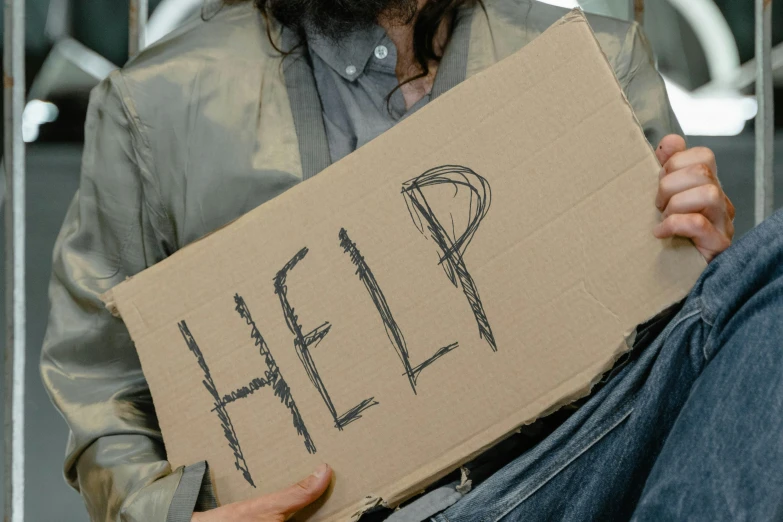 a man holding a cardboard sign that says help, by Matija Jama, trending on pexels, renaissance, homeless, avatar image, cast