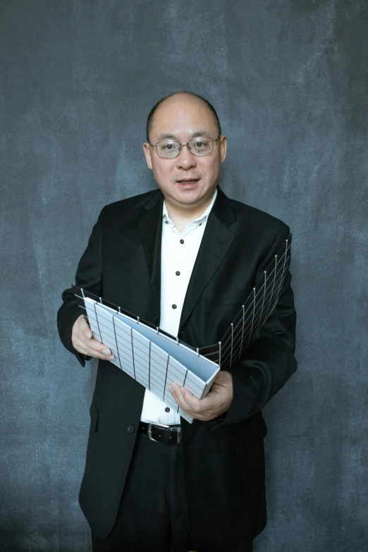 a man in a suit holding a sheet of paper, an album cover, inspired by Fei Danxu, architect, nerdy music teacher with phd, 2019 trending photo, professional profile photo