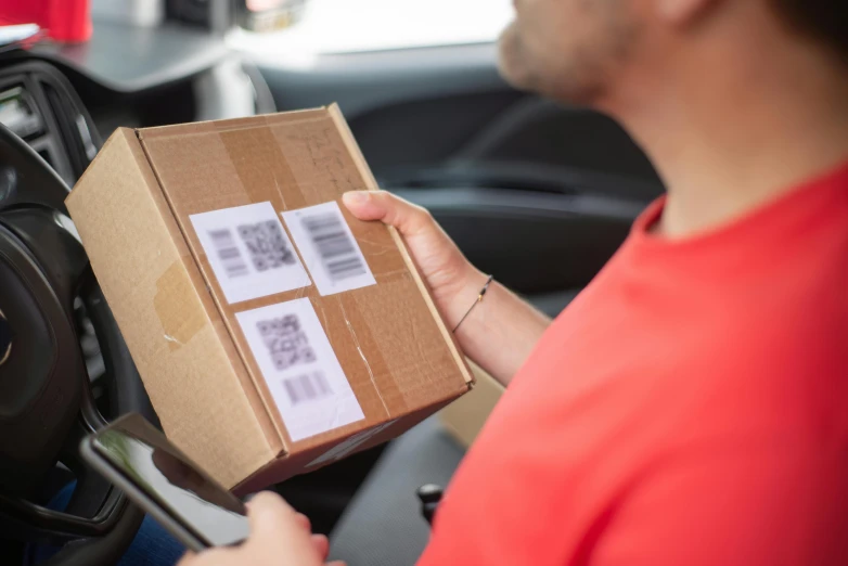 a man holding a cardboard box in a car, private press, ecommerce photograph, barcode, brown, thumbnail