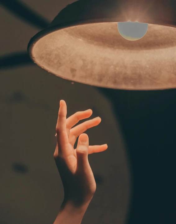 a person holding a light above their head, an album cover, inspired by Elsa Bleda, trending on pexels, magical realism, bump in form of hand, mood light, single light, (night)