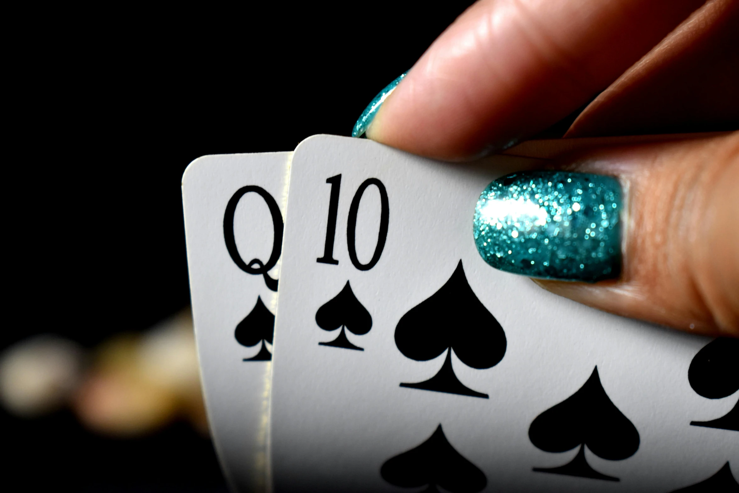 a close up of a person holding a playing card, trending on pixabay, black and teal paper, long nails, queen of the night, thumbnail