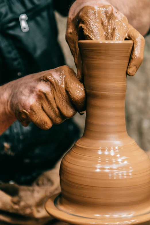 a man is making a vase out of clay, inspired by Hendrik Gerritsz Pot, trending on unsplash, brown, tall, 8l, low detail