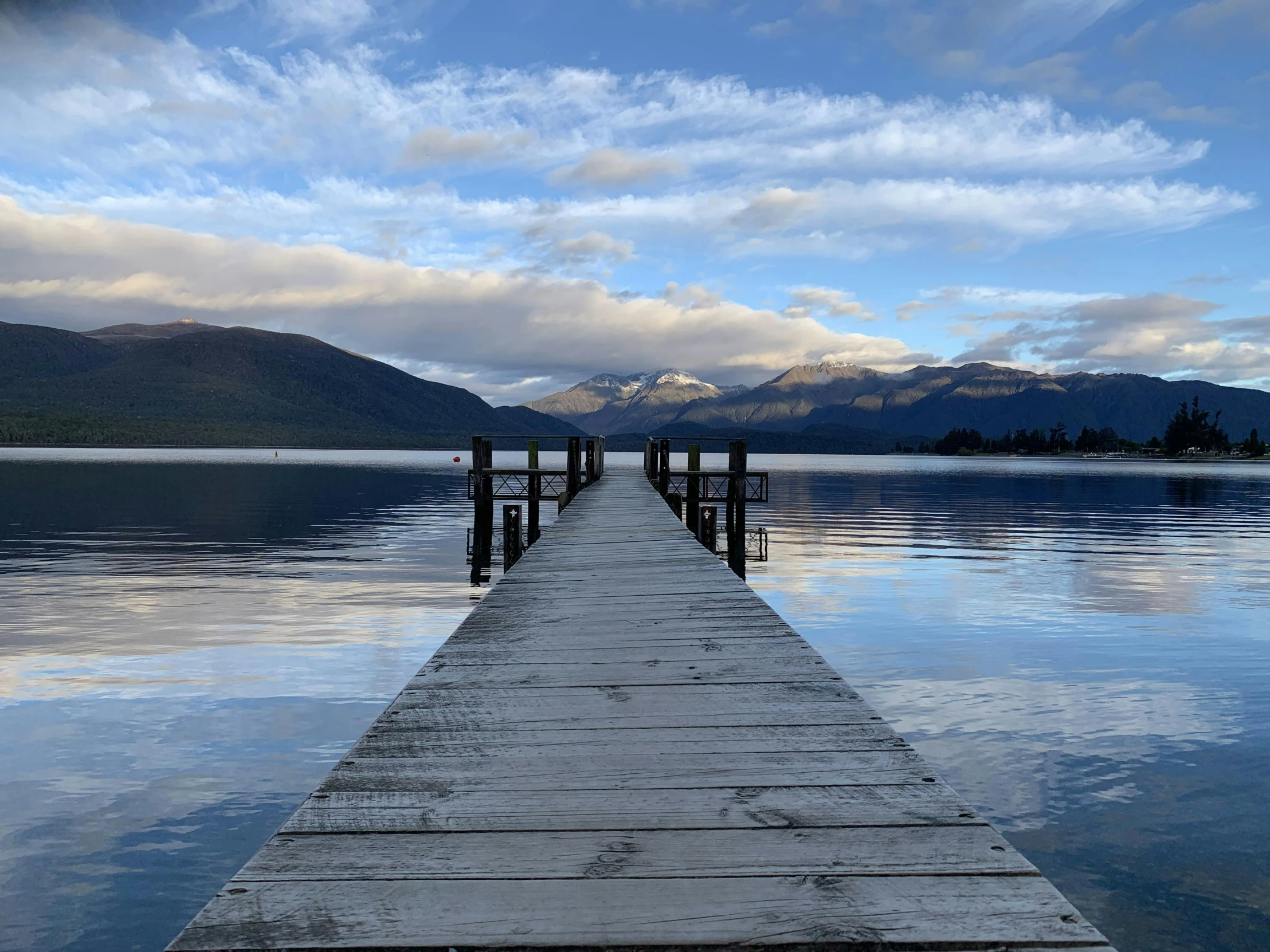 a dock on a lake with mountains in the background, by Sophie Pemberton, pexels contest winner, hurufiyya, new zeeland, head down, in a row, late summer evening