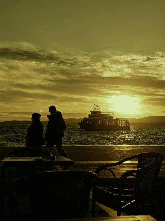 a couple of people that are sitting at a table, by Niko Henrichon, pexels contest winner, romanticism, ship, silhouette!!!, golden hues, bay area