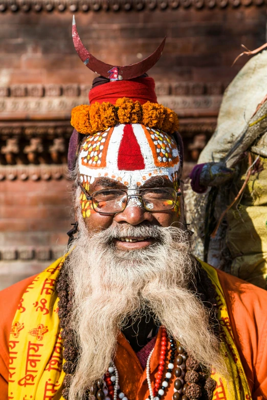 a man with a long beard standing in front of a building, hindu gods, long and orange mustache, nepal, sqare-jawed in medieval clothing