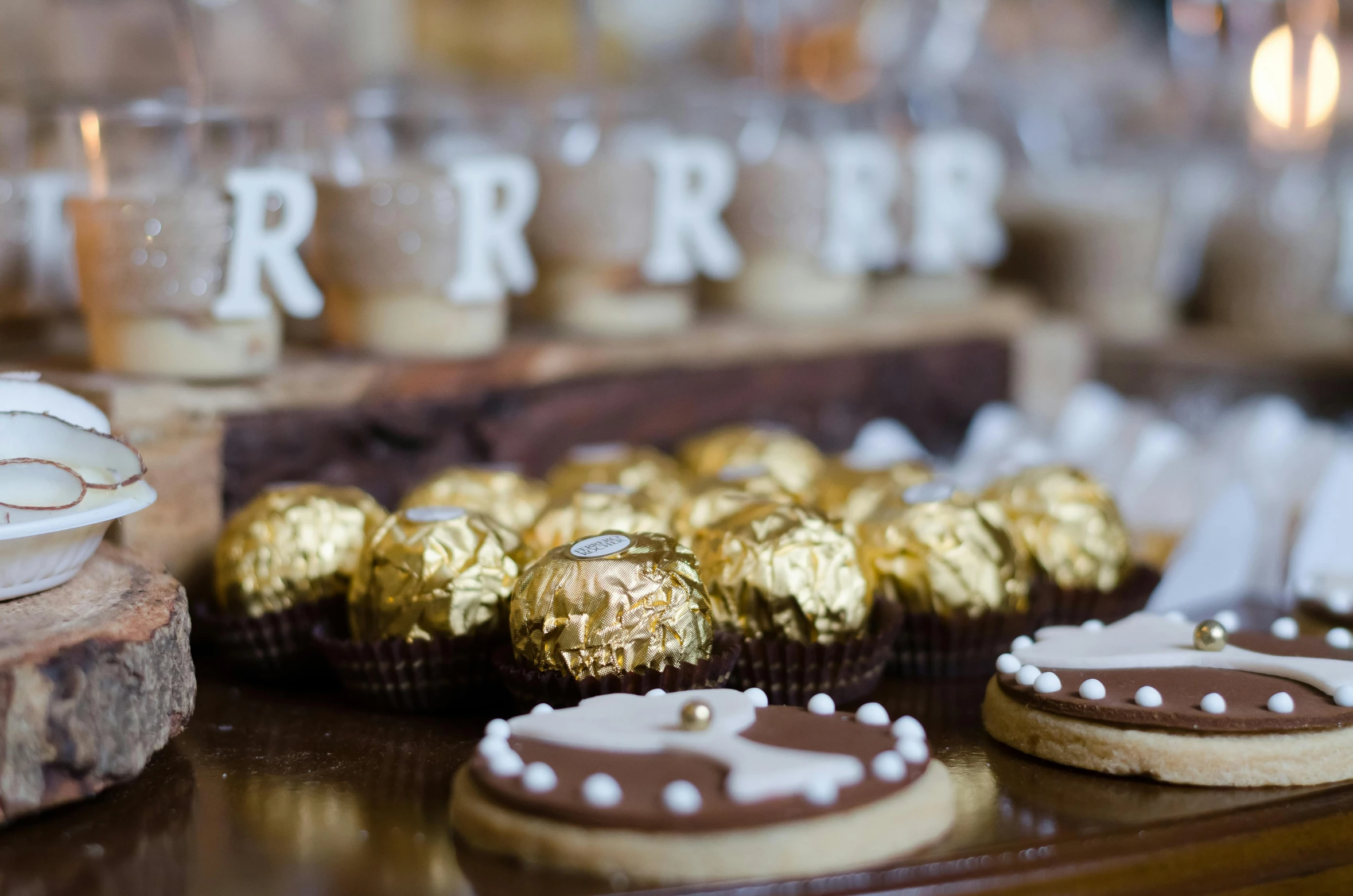 a table topped with lots of cookies and cookies, by Robbie Trevino, pexels, renaissance, wood and gold details, chocolate candy bar packaging, closeup, hgrenades