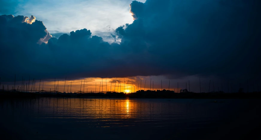 the sun is setting over a body of water, by Jan Tengnagel, pexels contest winner, hurufiyya, sun after a storm, thumbnail, peaceful evening harbor, humid evening