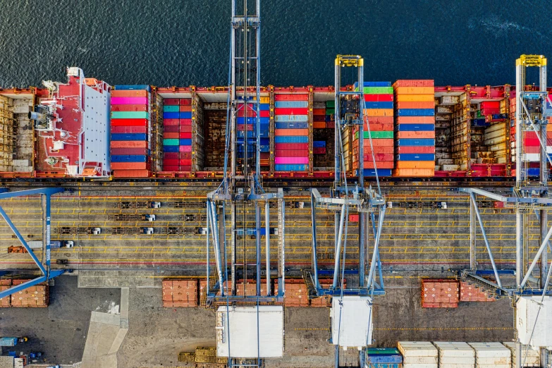 a large container ship sitting on top of a body of water, by Daniel Lieske, pexels contest winner, shipping docks, top down shot, various colors, panoramic shot