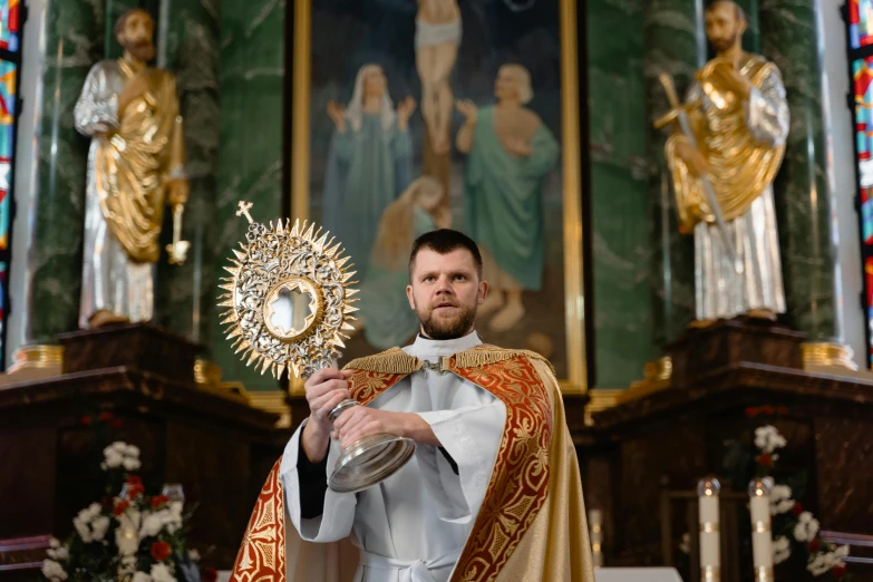 a man in a priest's robes holding a cross, a portrait, shutterstock, in a large cathedral, ornamental halo, photo shoot, holding a shield