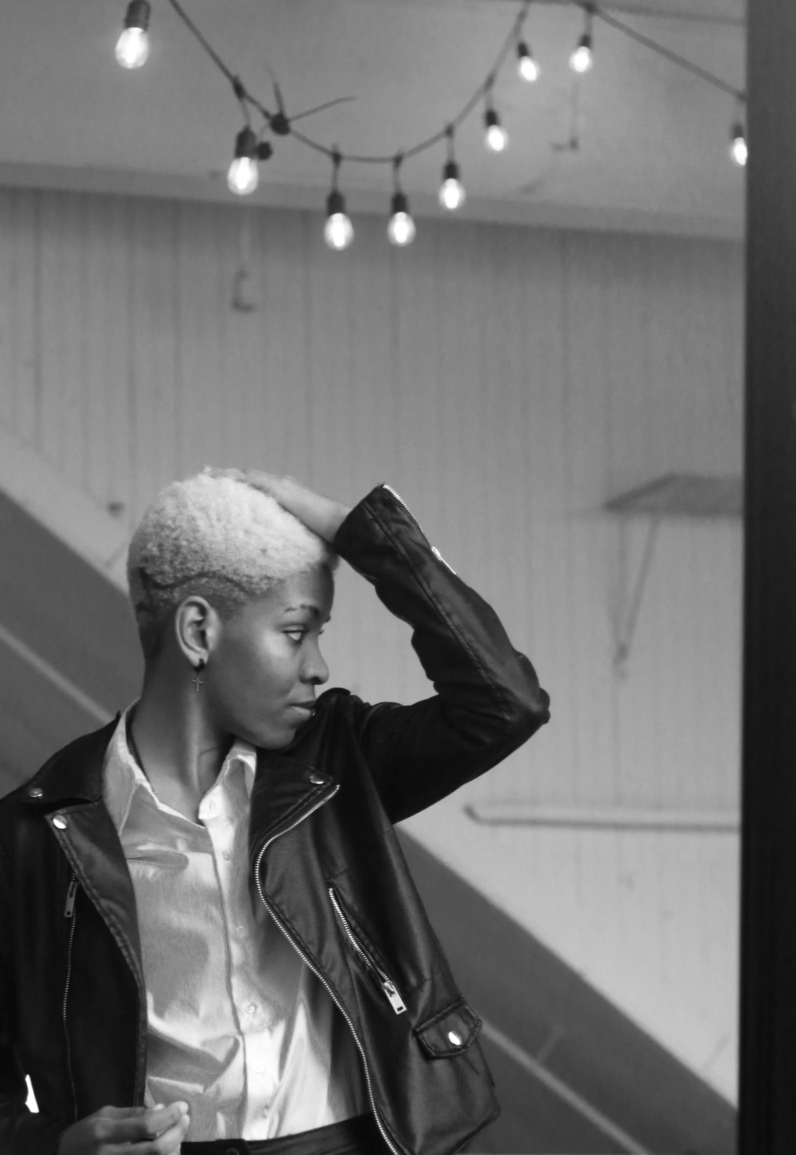 a black and white photo of a man in a leather jacket, by Maurycy Gottlieb, pexels contest winner, short platinum hair tomboy, black skin!!!, delicate androgynous prince, pastel'