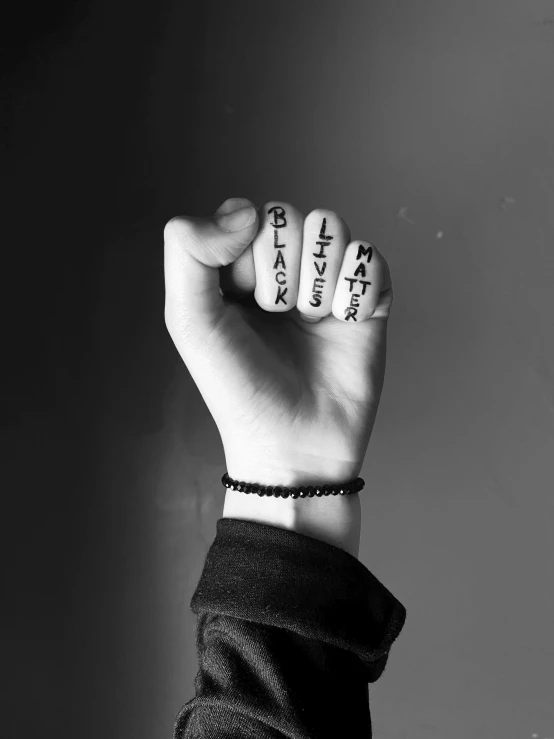a black and white photo of a fist with writing on it, a black and white photo, by Lucia Peka, unsplash, letterism, wearing gothic accessories, rings, lil peep, mark miner