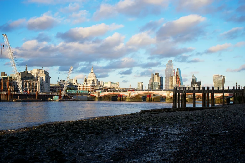 a bridge over a body of water with a city in the background, a photo, inspired by Thomas Struth, unsplash, london south bank, landscape of flat wastelands, beautiful late afternoon, 2000s photo