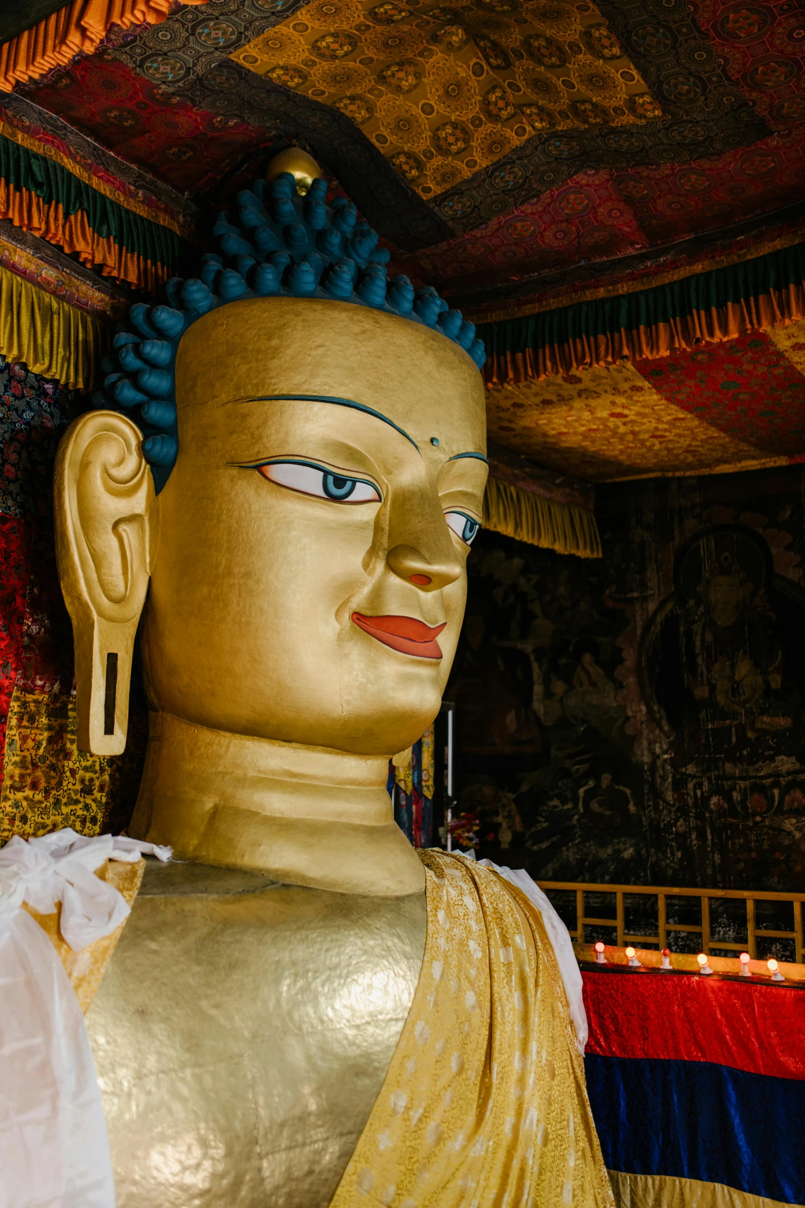 a close up of a statue of a person, in a temple, bhutan, large temples, looking serious