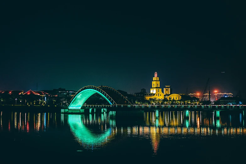 a bridge over a body of water at night, by Adam Marczyński, pexels contest winner, seville, brightly colored, hangzhou, ad image